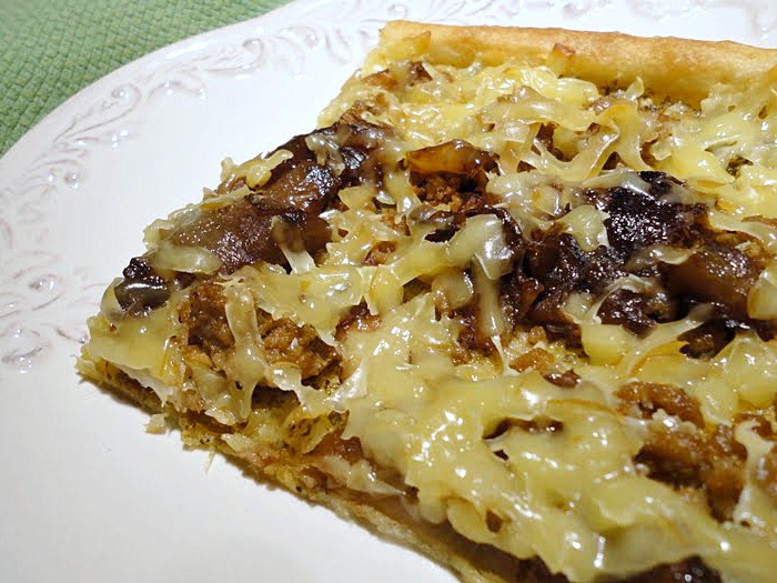 Homemade pizza with sausage, caramelized onions, and smoked Gouda cheese
